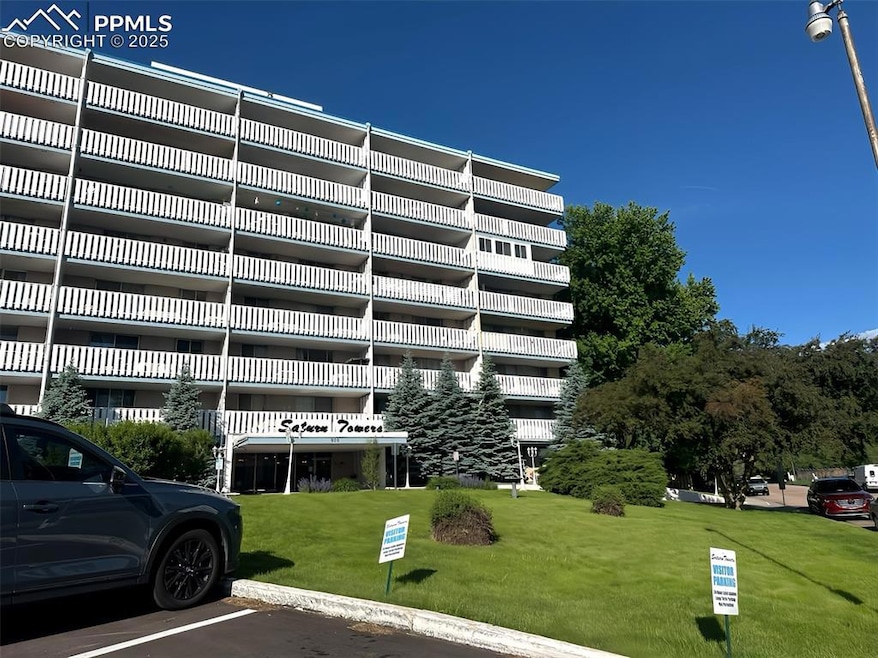 View of apartment building / complex featuring uncovered parking