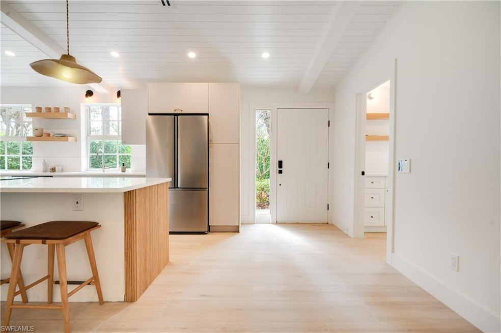 Kitchen featuring a kitchen breakfast bar, light c
