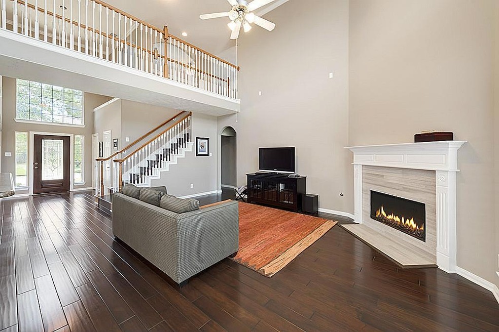 Stunning 2-story ceiling from entry through living room. View of the expansive first-floor living space. Fireplace is upgraded with Limestone. Upgraded espresso hardwoods.