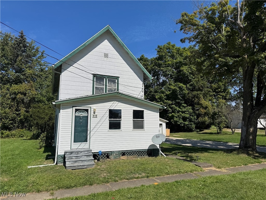 View of property exterior featuring a lawn and entry steps
