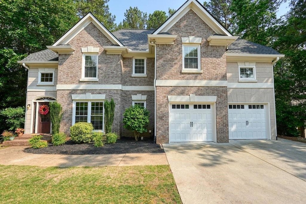 View of front of house with concrete driveway, a garage, a shingled roof, and brick siding
