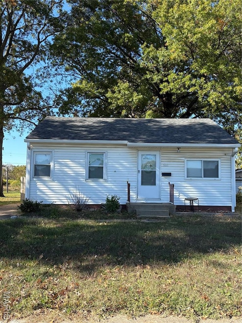 View of front of home with a front yard and a shingled roof