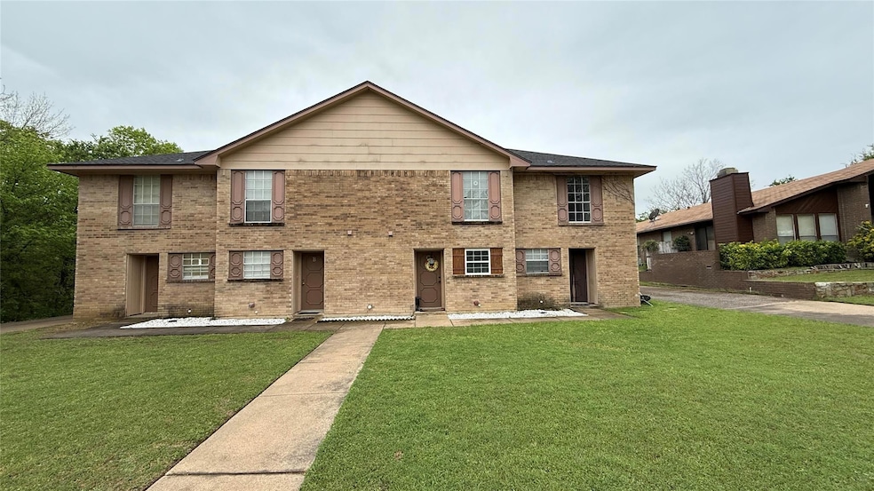 View of front of house with a front yard and brick