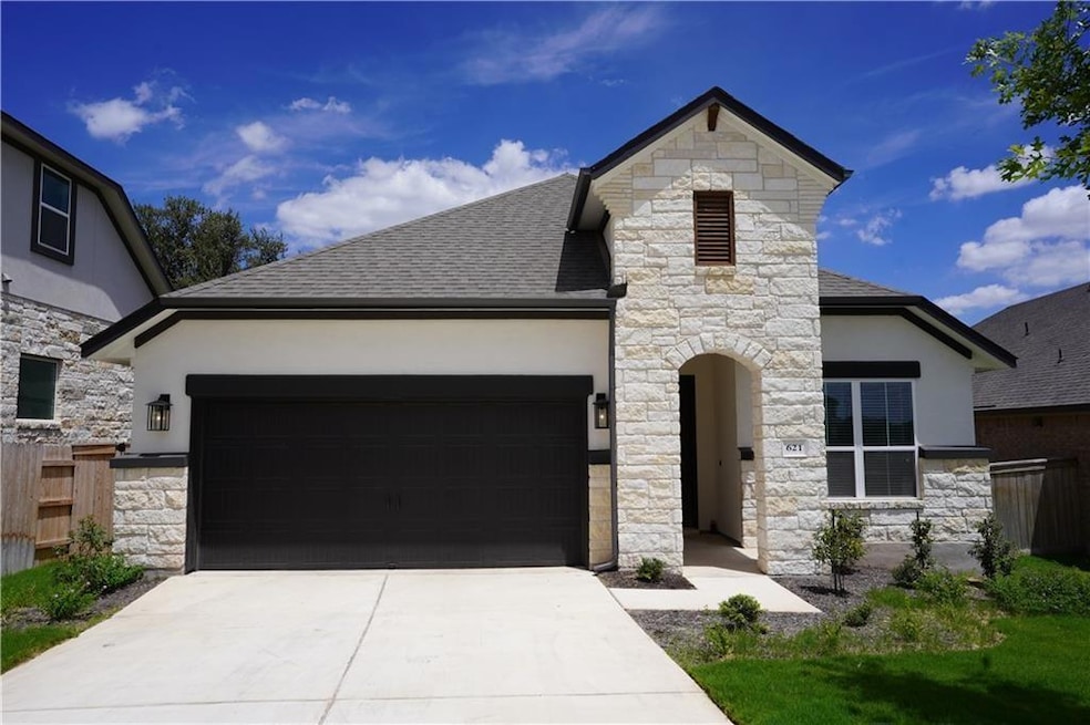 French country inspired facade with stone siding,