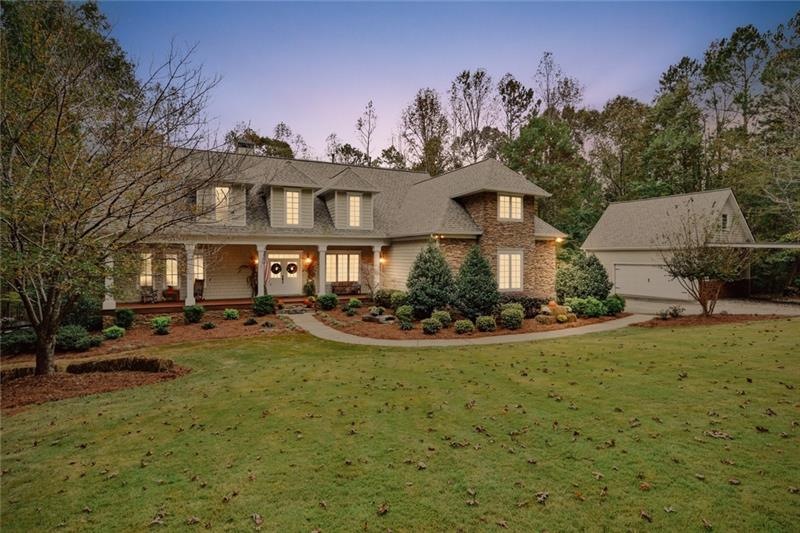 Front of home featuring a large yard with lush Zoy