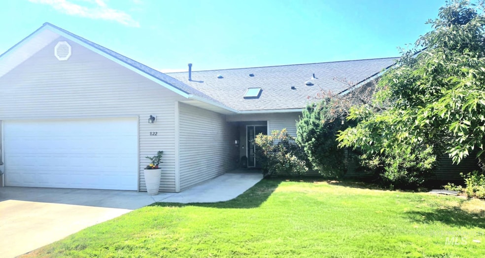 Ranch-style house featuring a garage, a shingled roof, driveway, and a front lawn