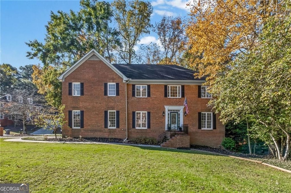 Colonial house with brick siding and a front lawn
