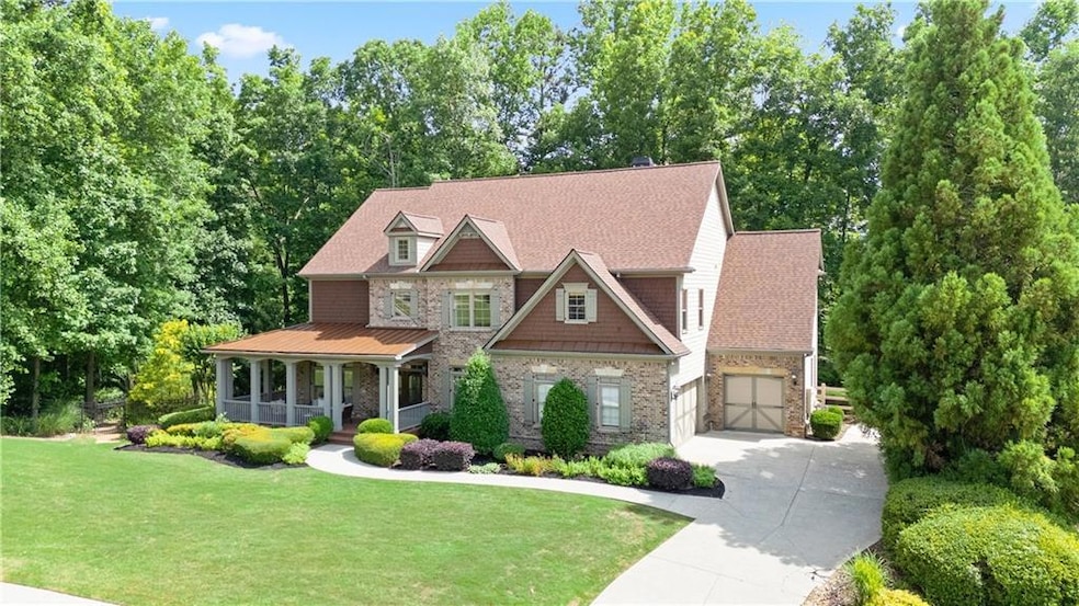 Craftsman-style house featuring a porch, concrete driveway, a front lawn, stone siding, and roof with shingles