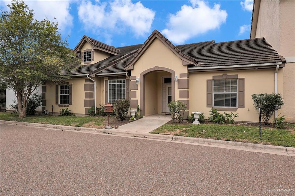 View of front of house with stucco siding and a tile roof