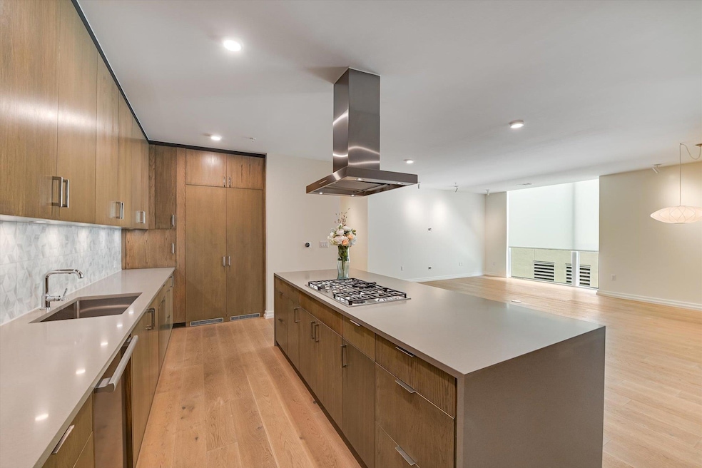 Kitchen featuring island exhaust hood, a sink, li