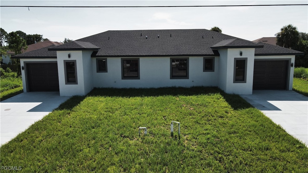 View of front of house featuring driveway, a shingled roof, an attached garage, a front lawn, and stucco siding