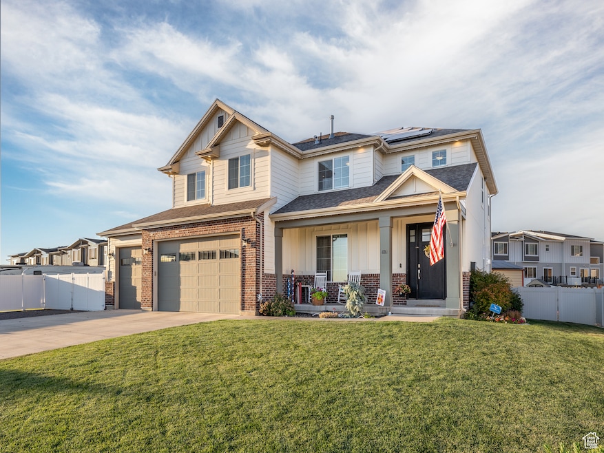 Craftsman house with a front yard, a garage, solar panels, and covered porch