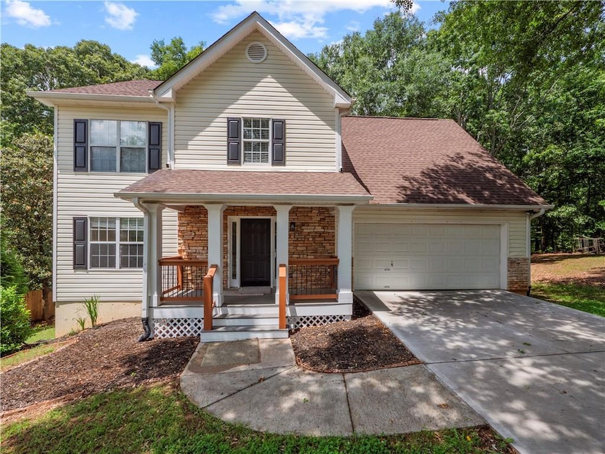 View of front of home with covered porch, a garage