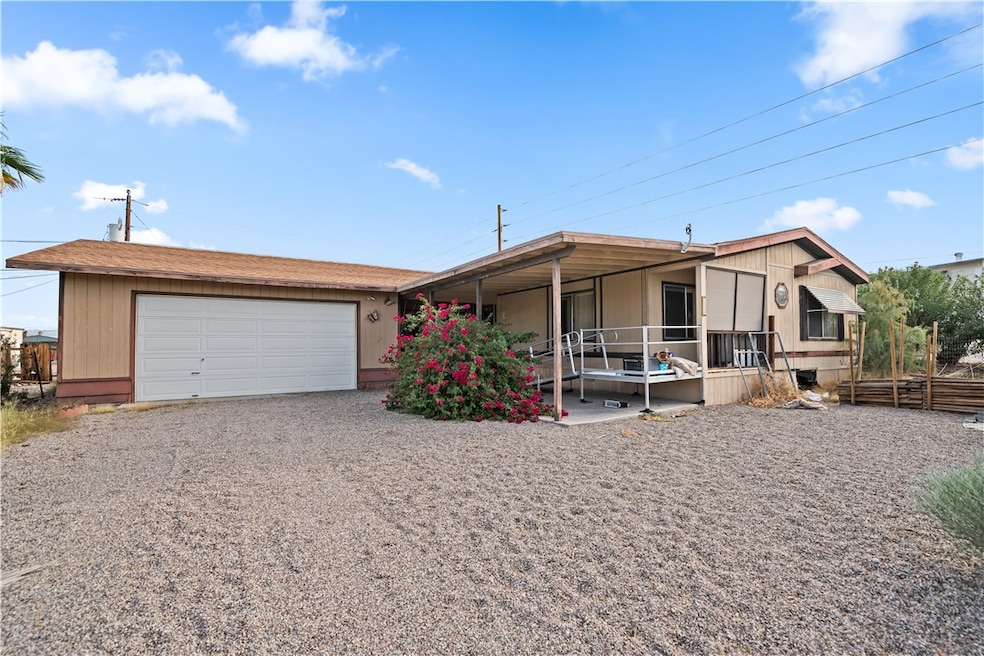 View of front of home featuring an attached garage and gravel driveway