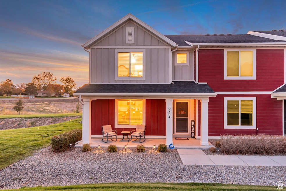 View of front of home featuring board and batten siding, a porch, roof with shingles, and a lawn