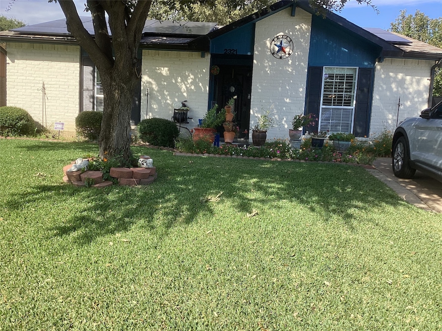 View of front of home with roof mounted solar panels paid for and will remain with home