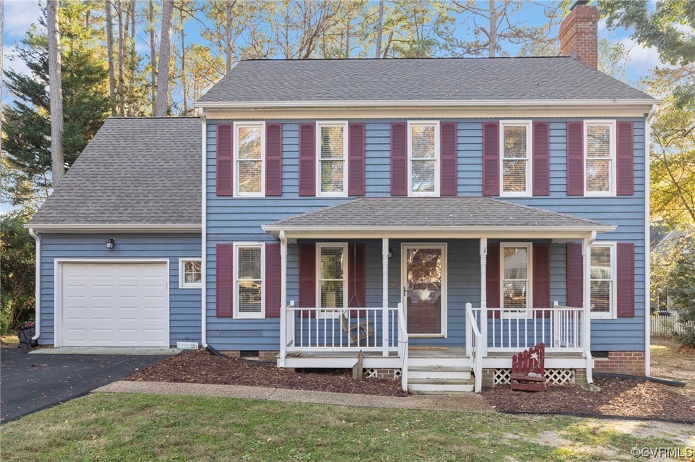 Colonial-style house featuring a garage and covere