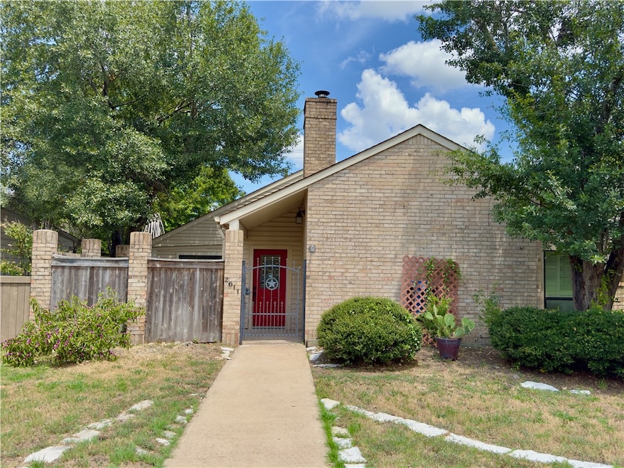 View of front of house with a chimney and brick siding