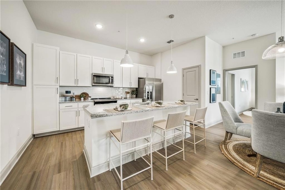 Kitchen with white cabinetry, hanging light fixtur