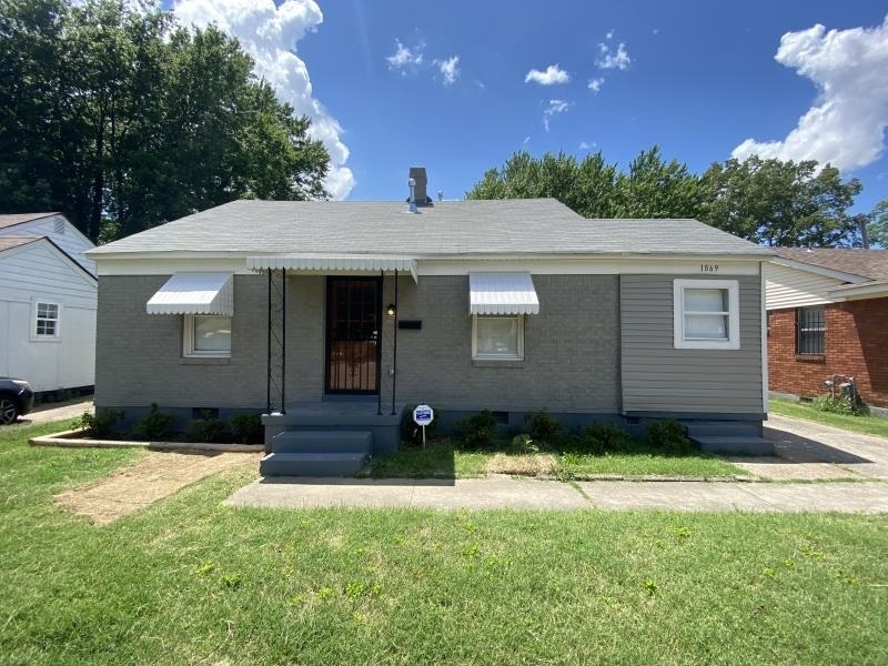 Bungalow with brick siding and a front yard