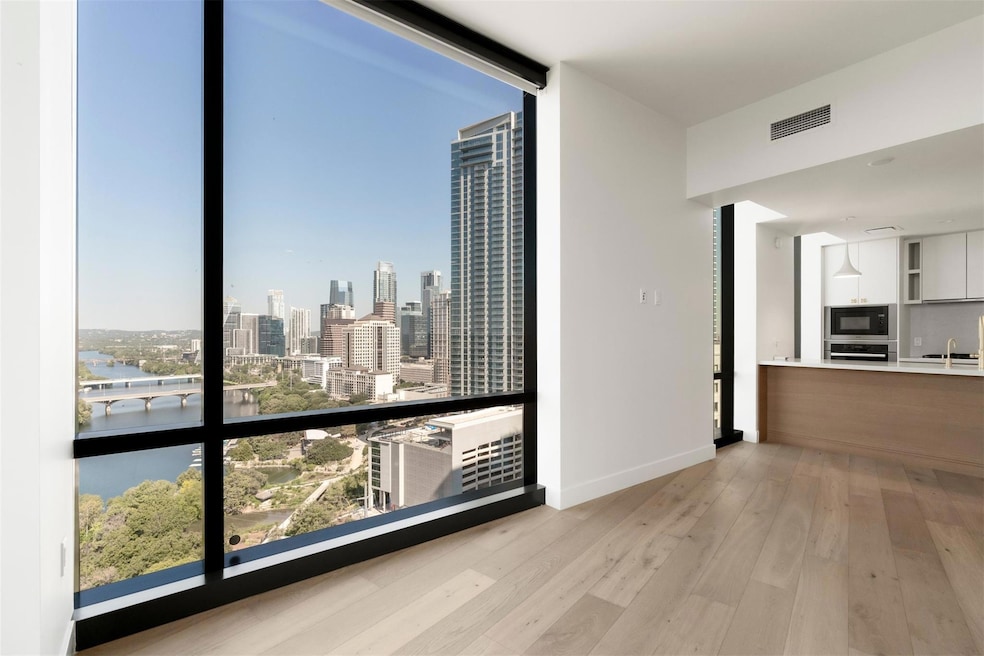 Floor-to-ceiling glass draws the city right into your living room, offering sweeping views of downtown Austin and Lady Bird Lake that are nothing short of captivating