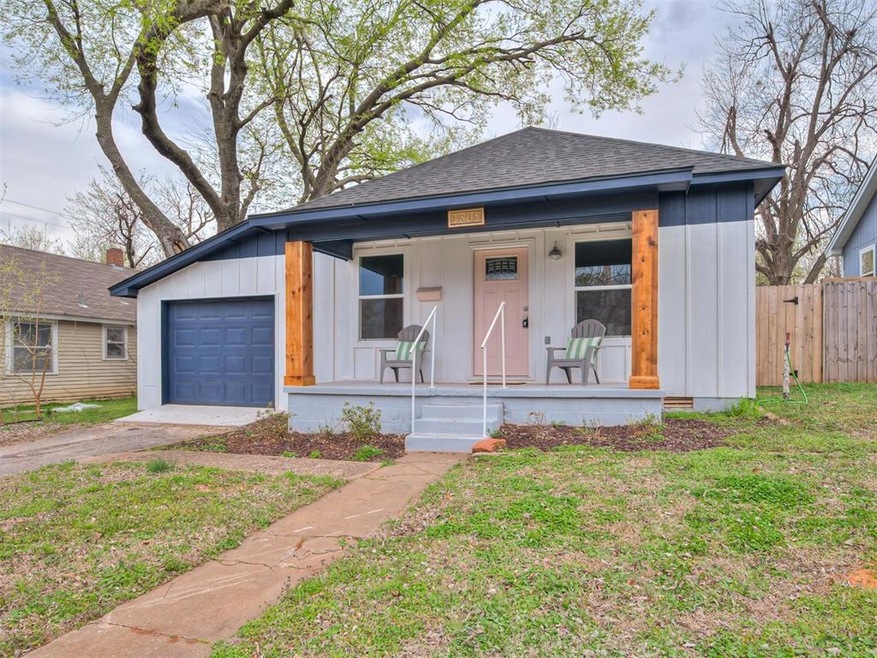 View of front of home with covered porch, a garage