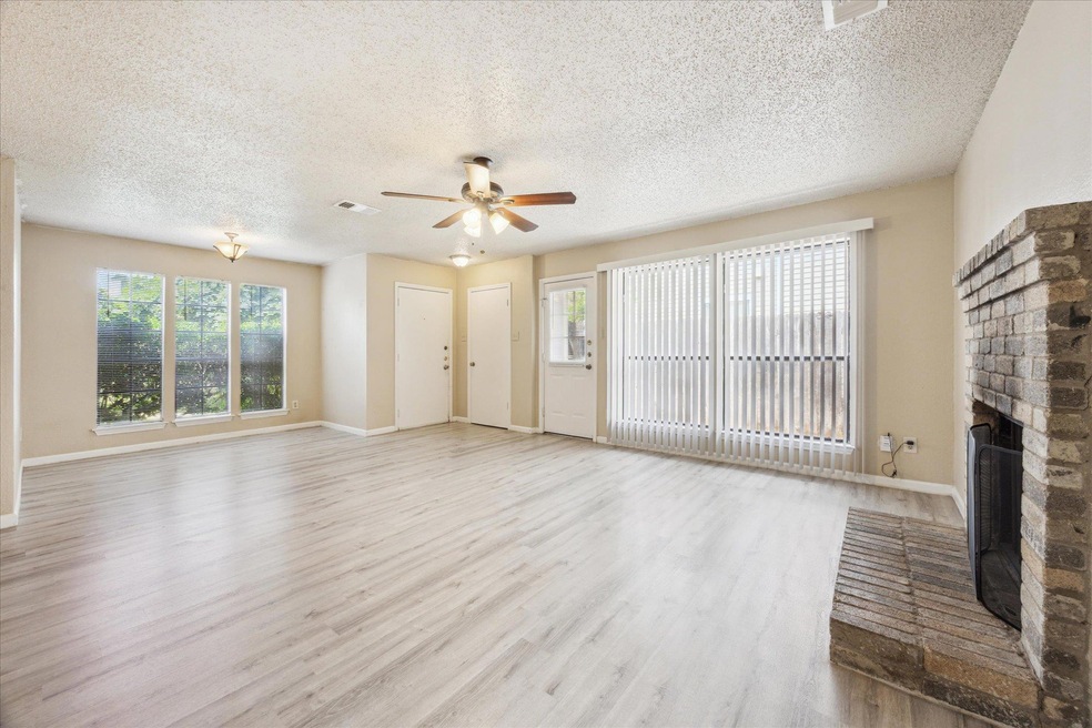 Unfurnished living room with a ceiling fan, a fir