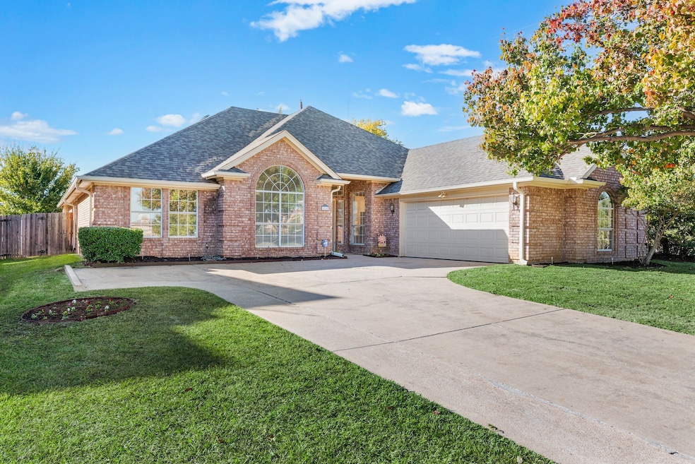 View of front facade featuring roof with shingles, a front lawn, and brick siding