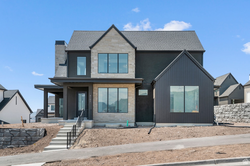 Modern home featuring stone siding, a chimney, and a shingled roof