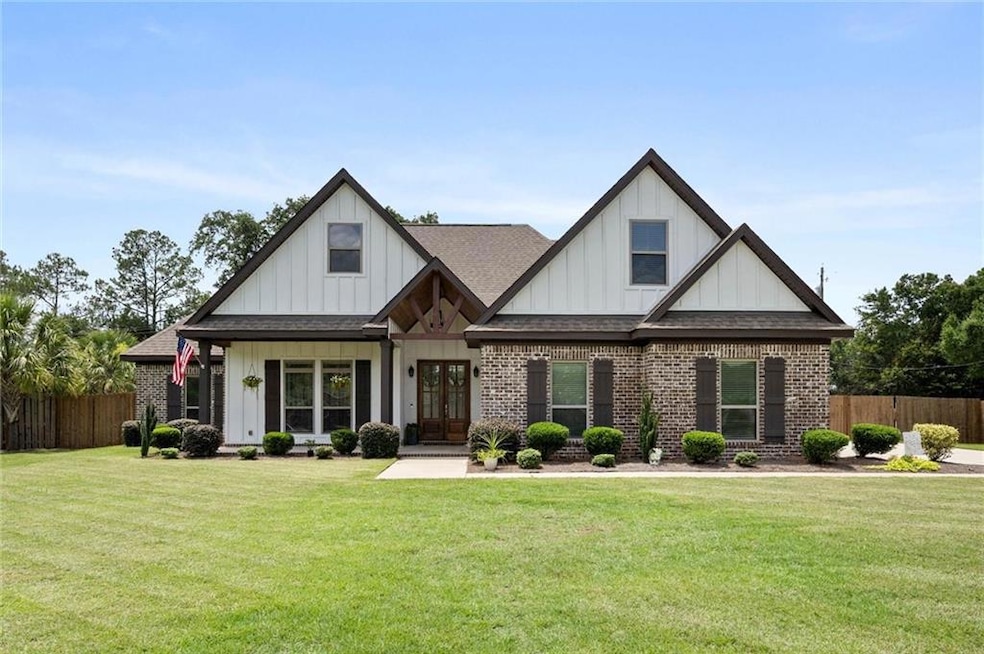 View of front of home featuring roof with shingles, board and batten siding, brick siding, and french doors
