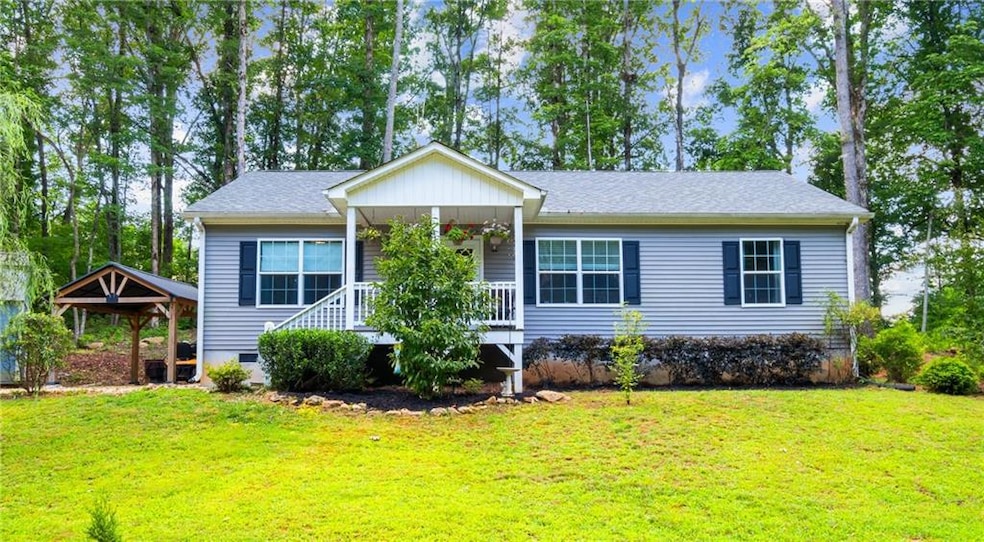 Ranch-style home featuring a front lawn, a porch, and roof with shingles