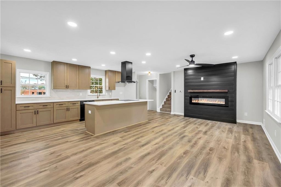 Kitchen featuring ceiling fan, a center island, wa