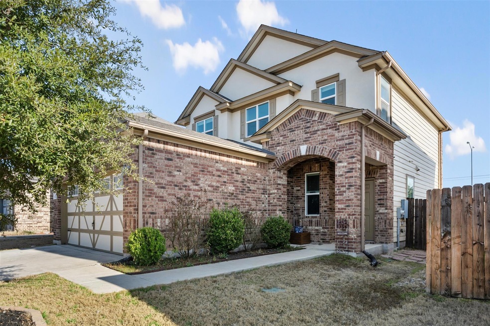 View of front facade with a garage, brick siding,