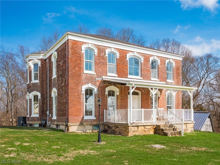 View of front of property with a front lawn, central AC, and a porch
