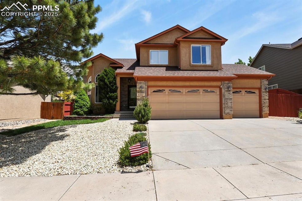 View of front of house with concrete driveway, stucco siding, and stone siding