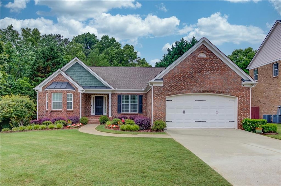 View of front of property featuring brick siding, a front yard, concrete driveway, and an attached garage