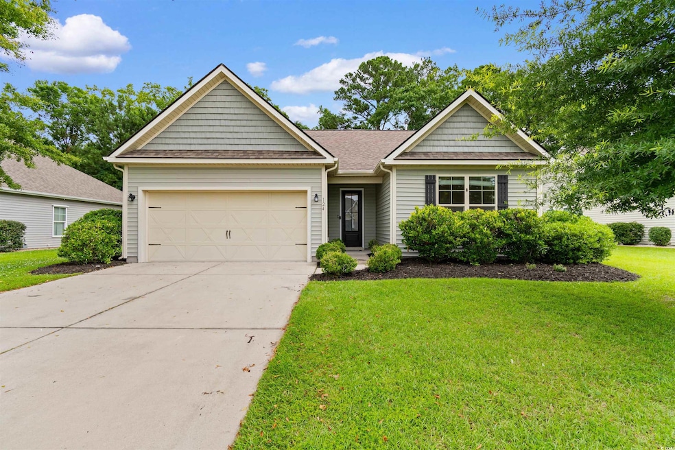 View of front of home with a garage, concrete driveway, a front yard, and roof with shingles