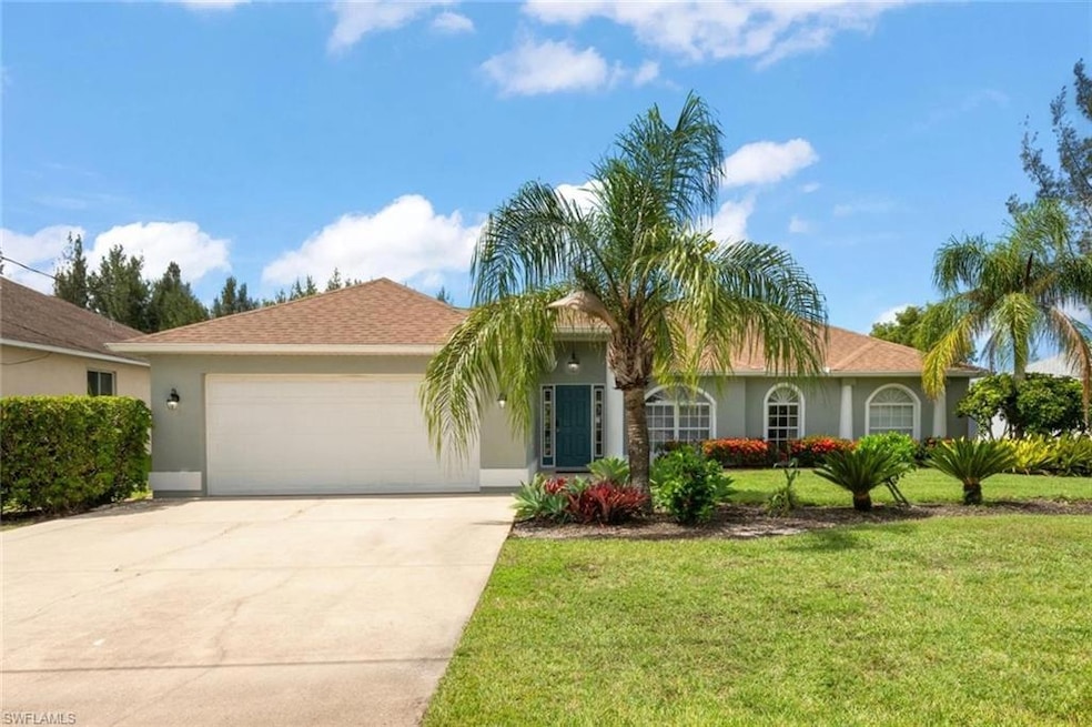 View of front of property featuring stucco siding, driveway, a garage, and a front lawn