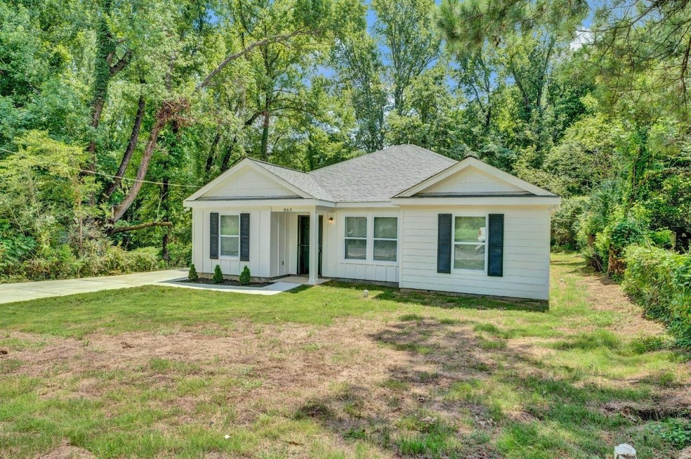 Ranch-style home with board and batten siding, a front yard, and roof with shingles