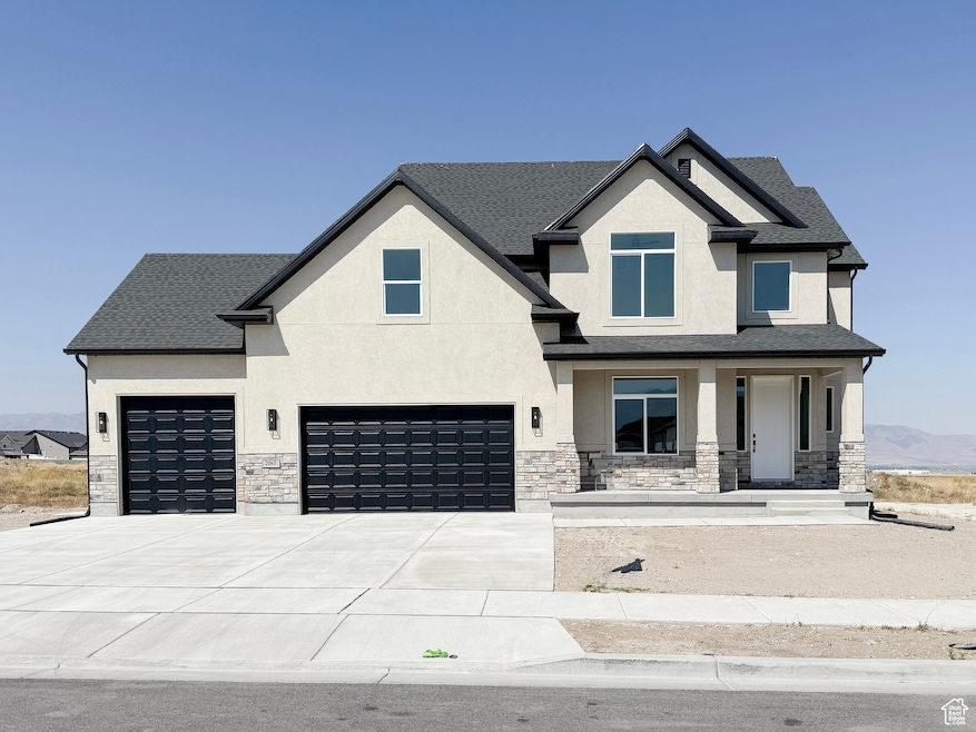View of front of property featuring a porch, stucco siding, stone siding, and concrete driveway