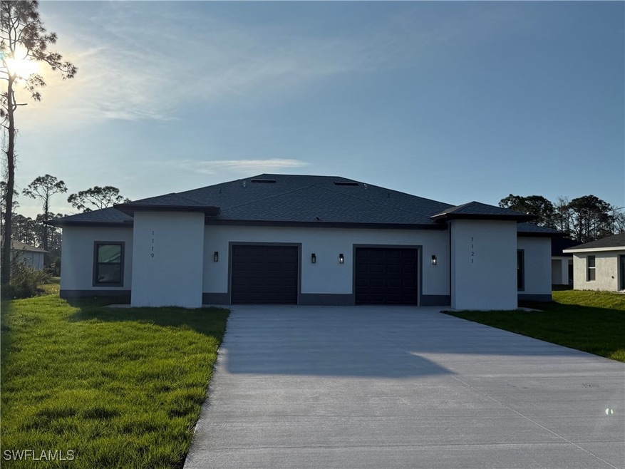 View of front of property with a garage, stucco si