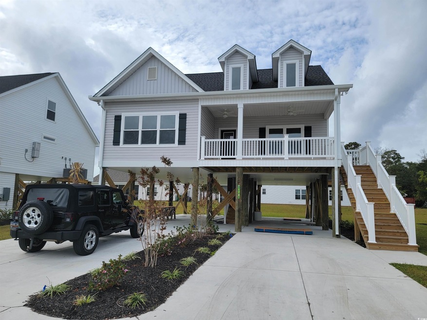 Coastal inspired home with a porch and a carport