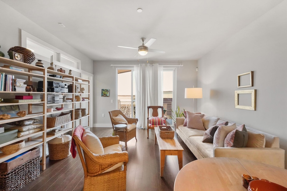 Living area featuring ceiling fan, wood-type floo