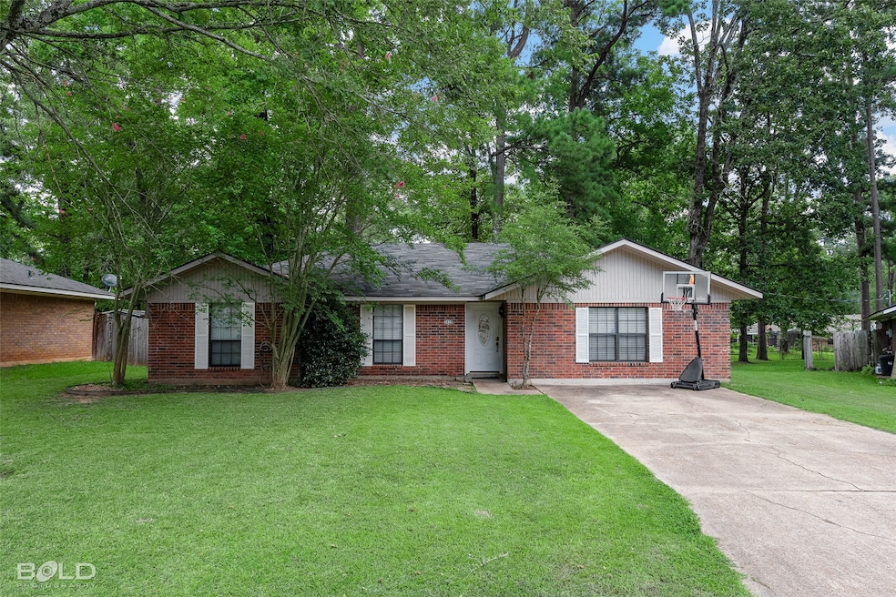 Ranch-style home with a front lawn, concrete driveway, and brick siding