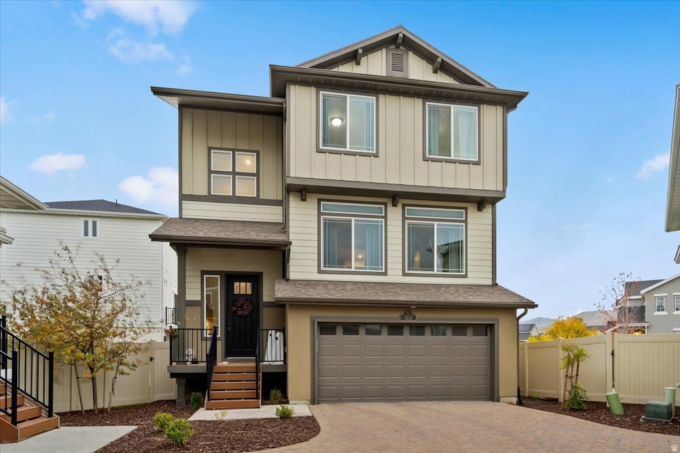 View of front of home with a shingled roof, decorative driveway, an attached garage, and board and batten siding