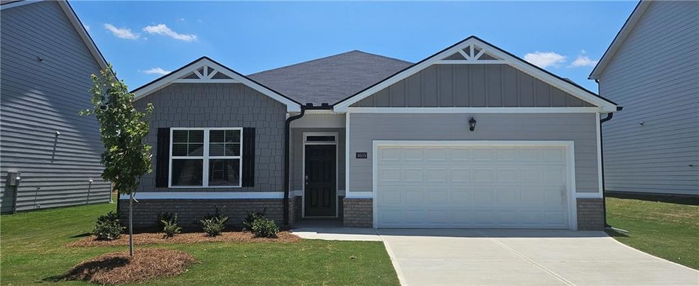 Craftsman-style house with a front yard and a gara