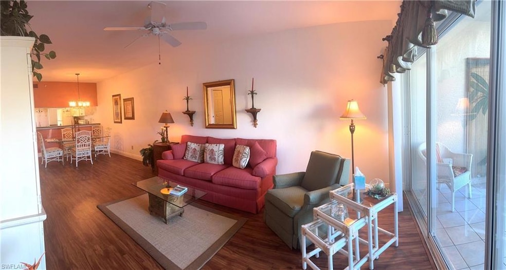 Living room featuring dark hardwood / wood-style floors and ceiling fan with notable chandelier