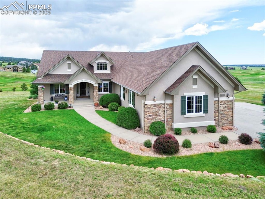 View of front facade with stucco siding, stone siding, a porch, a front lawn, and a shingled roof