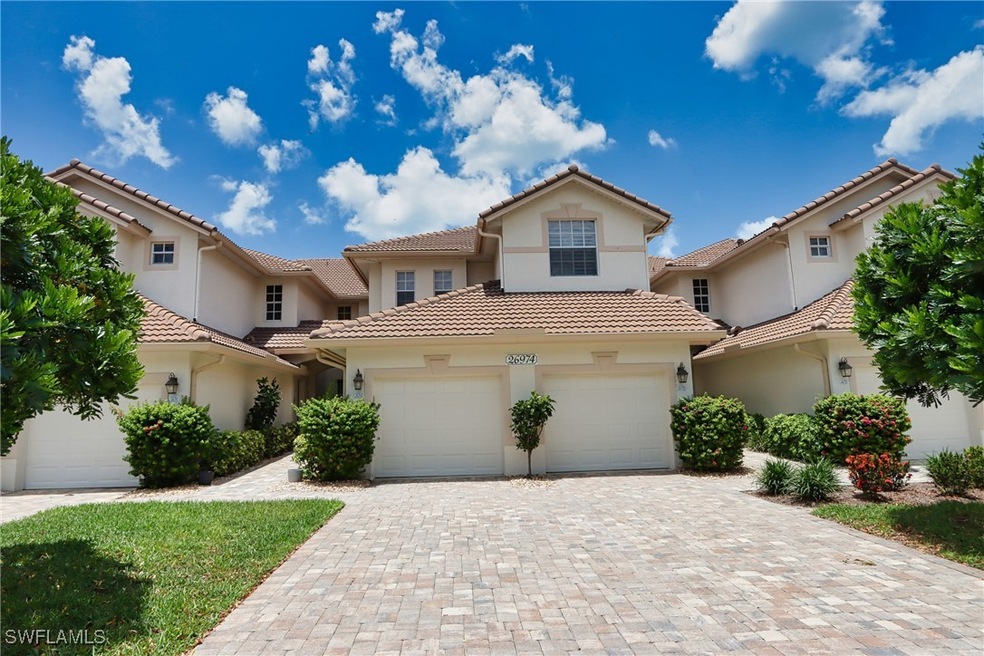 View of front facade with stucco siding, decorative driveway, and a tiled roof