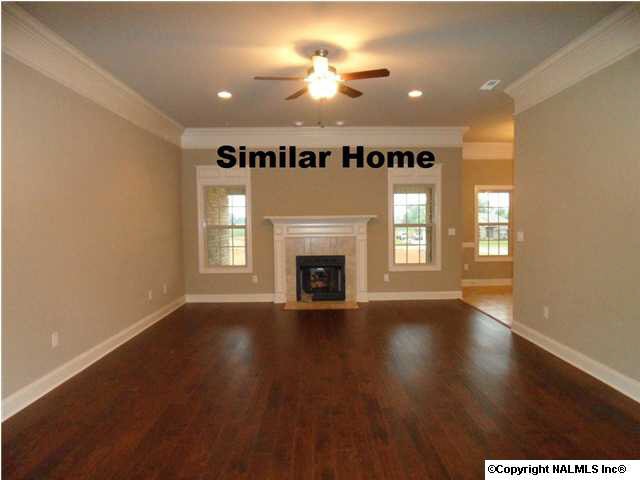 Family room with 10 foot ceiling, hardwood flooring, ceiling fan, fireplace, recessed lights.